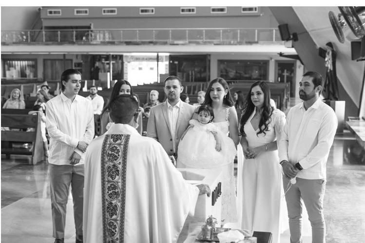 familia de pie durante la ceremonia de bautizo en la iglesia