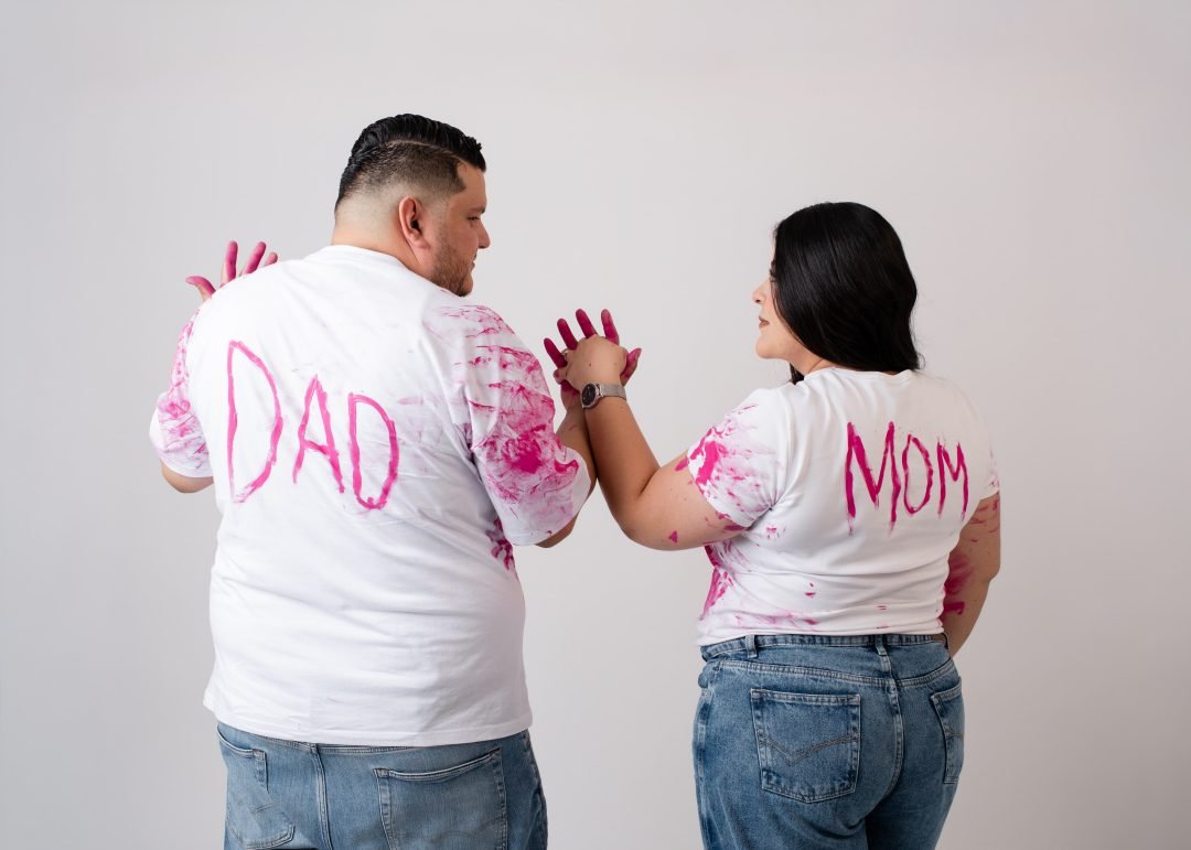 pareja con playeras de mamá y papá con huellas de pintura rosa