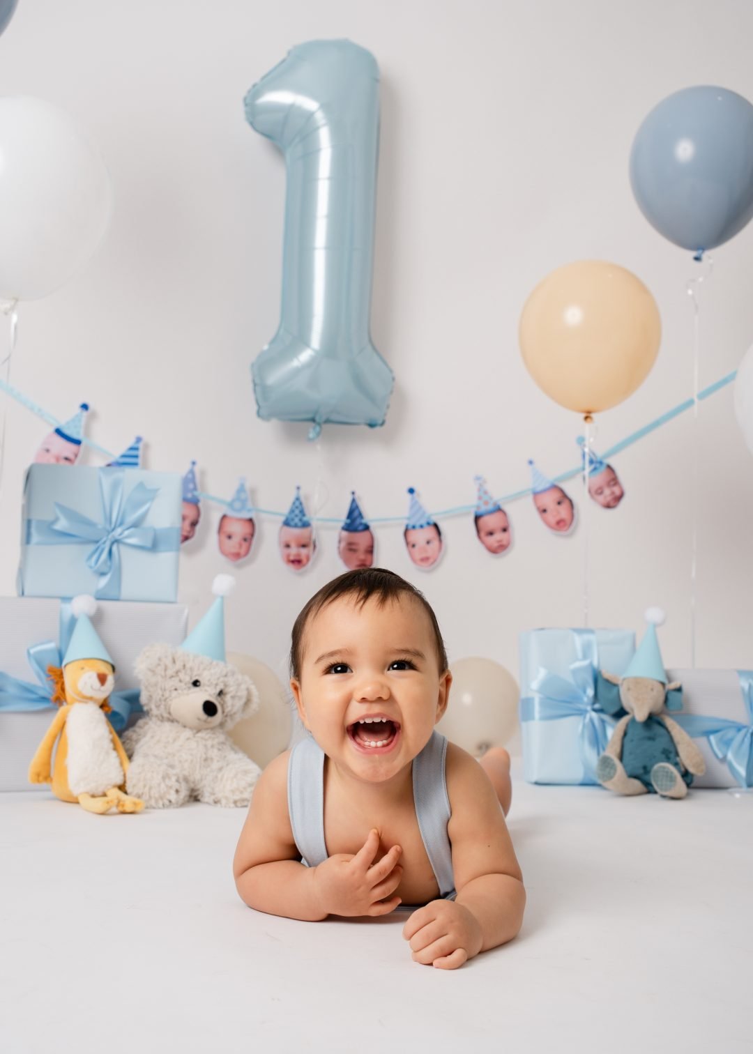 bebé con globos azules y letrero de primer año