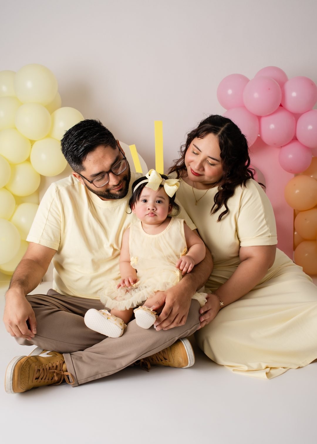familia con playeras amarillas y globos en su sesión de un año